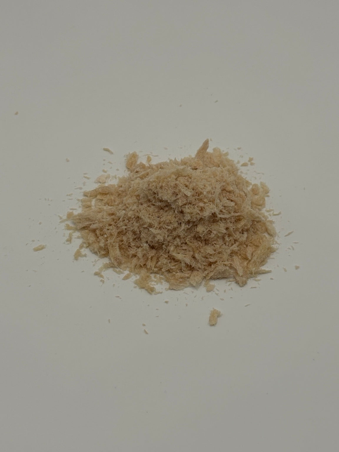 Close-up of Hallie Farm freeze-dried chicken pet food topper showing its delicate flakes and shredded texture